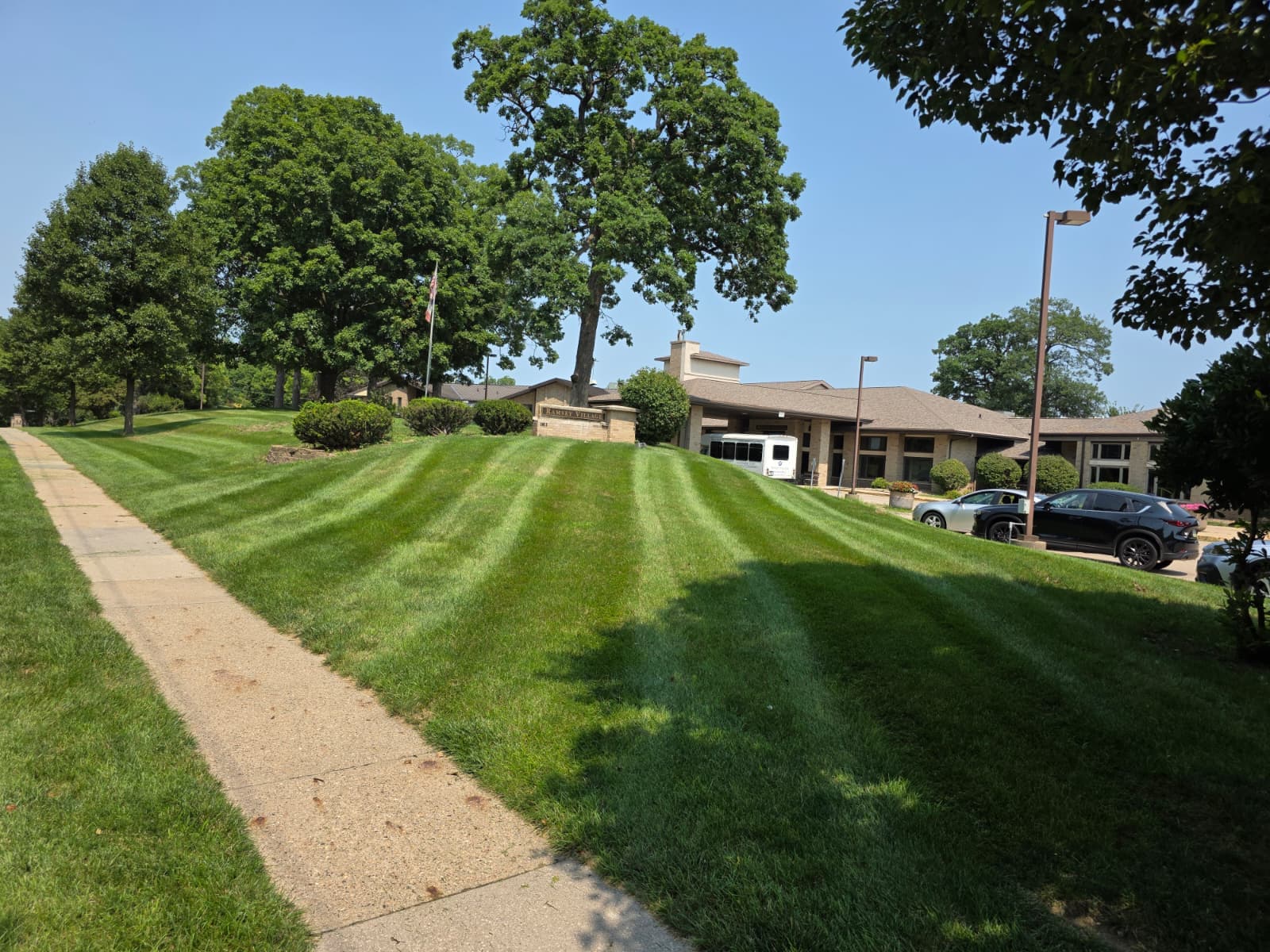 Striped green lawn beside a building and paved paths