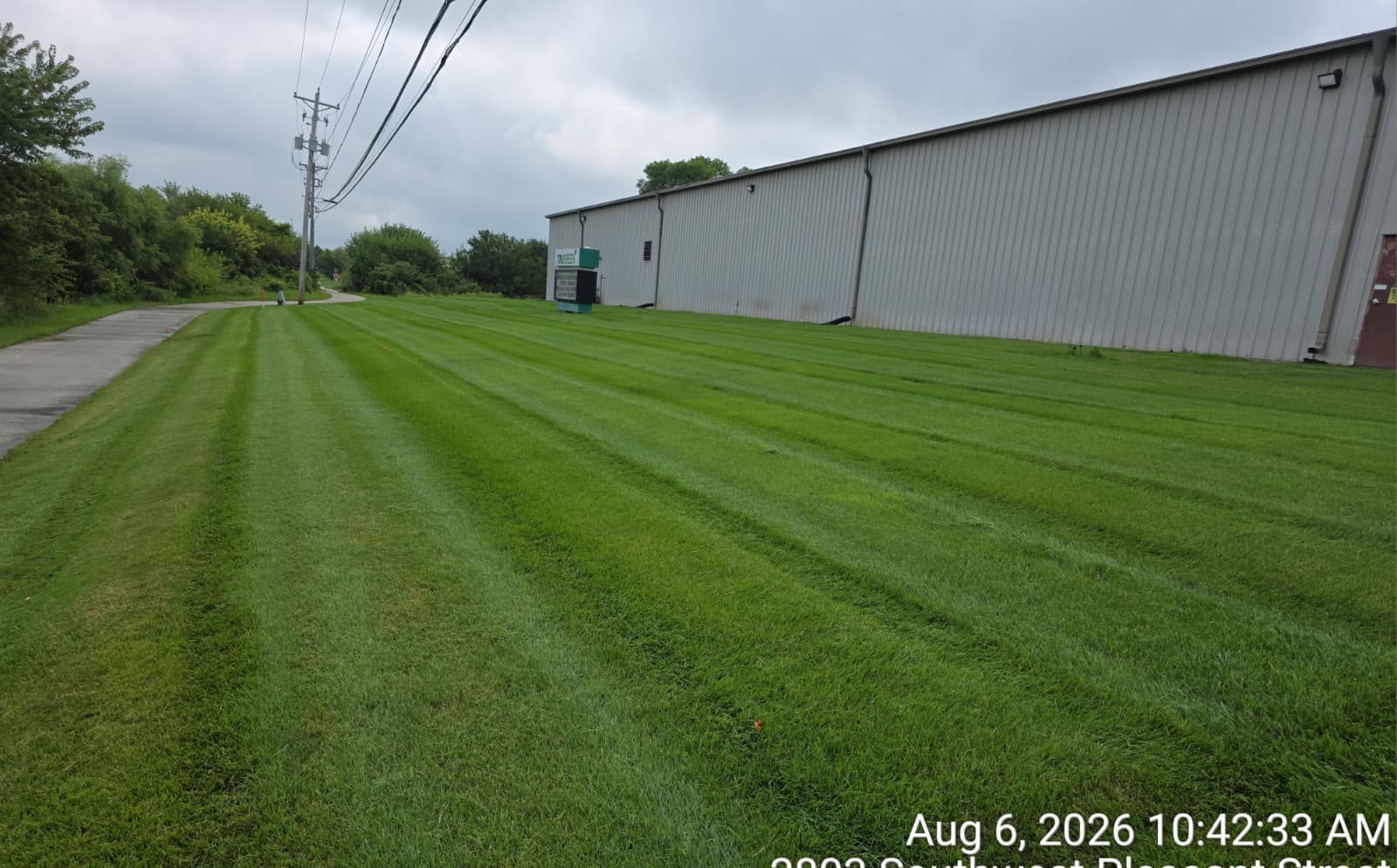 Striped lawn beside a long metal-sided building